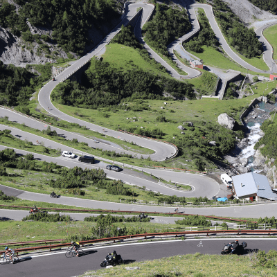 Overhead view of cars and bikes driving up switchbacks of the Stelvio Pass from Bormio in Italy